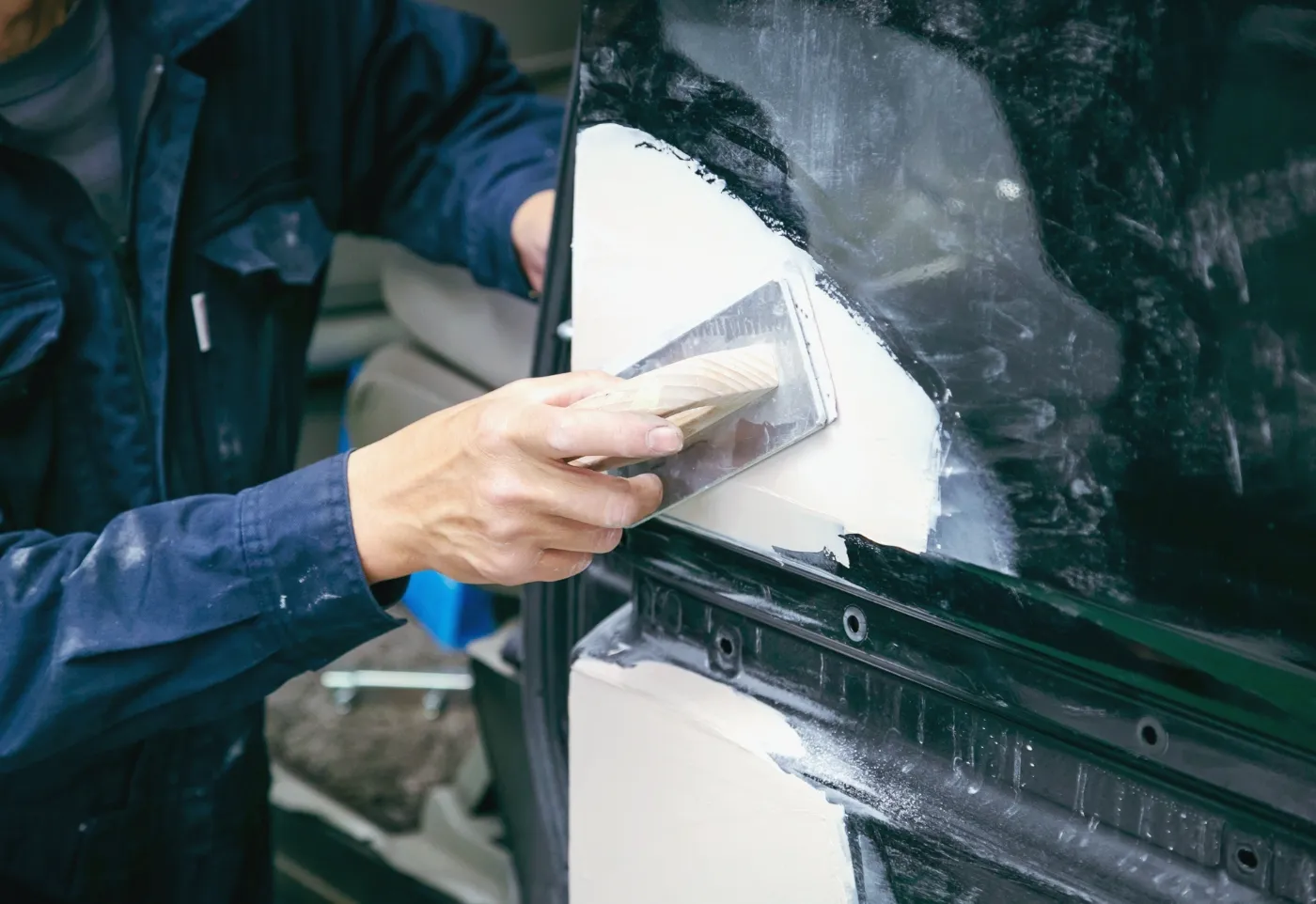 車のボディーにパテを塗ってる様子